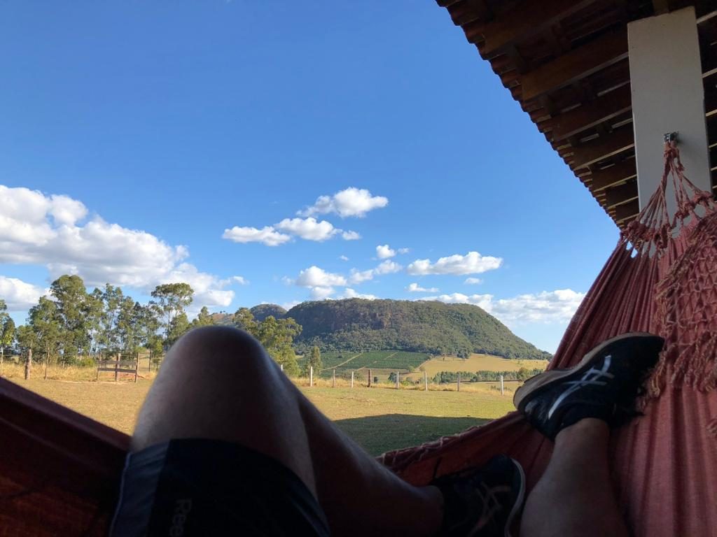 Vista do morro de topo plano e dos campos, de dentro de uma rede na varanda