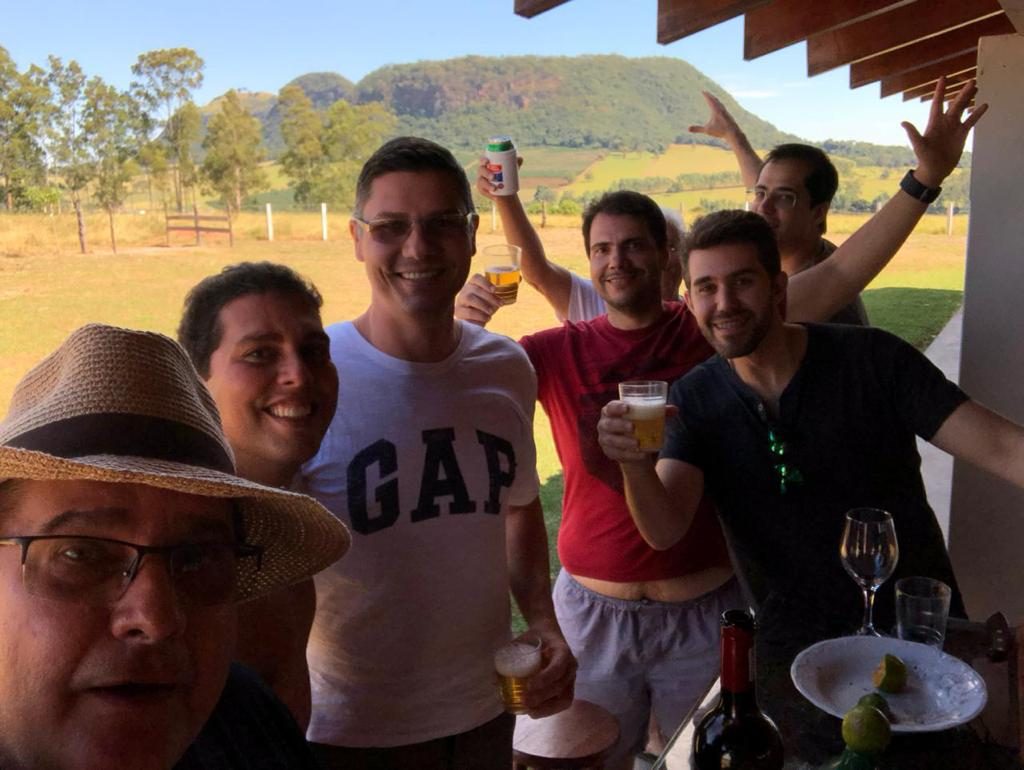 Grupo de amigos reunidos com o morro ao fundo